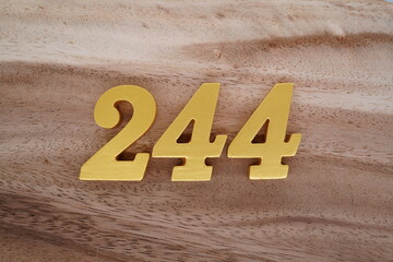 Golden Arabic numerals on real wood with brown and white pattern.