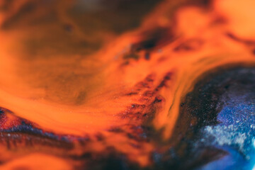 Ink background. Abstract colorful design. Creative paint mixture. Orange dark blue colors blend