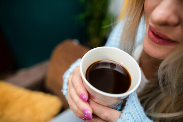 Close-up view of a girl with a mug of coffee in her hands.