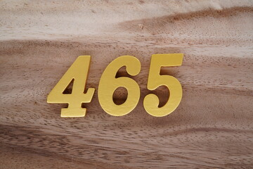 Golden Arabic numerals on real wood with brown and white pattern.