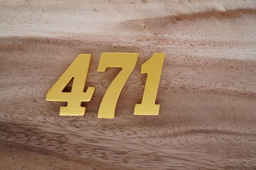Golden Arabic numerals on real wood with brown and white pattern.