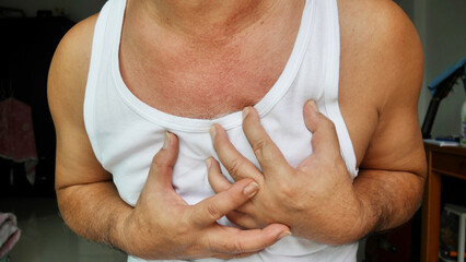 Asian man wearing white shirt has chest pain
