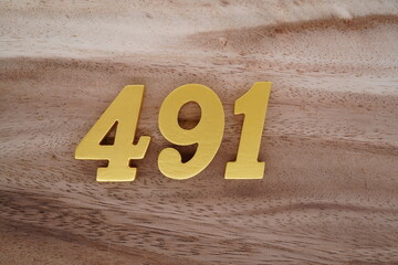 Golden Arabic numerals on real wood with brown and white pattern.