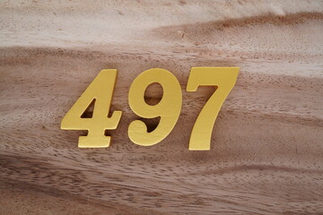 Golden Arabic numerals on real wood with brown and white pattern.