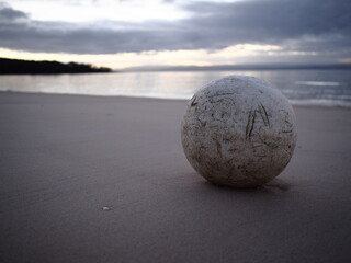 Fototapeta na wymiar Worn sphere on the beach