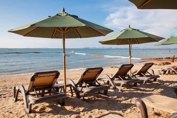 Beach chairs with umbrella outdoor swimming pool on the beach.