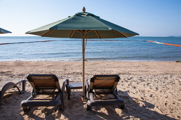 Beach chairs with umbrella outdoor swimming pool on the beach.