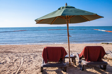 Beach chairs with umbrella outdoor swimming pool on the beach.