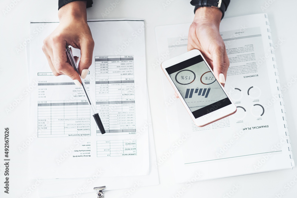 Poster calculating ways to increase her profits. closeup shot of an unrecognisable businesswoman using a ce