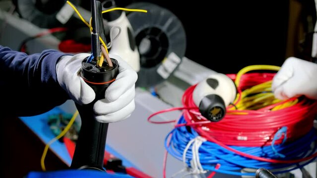 Engineers create pump plug to charge electric vehicle. Specialists of maintenance deal with wires and cable at portable charging station close view