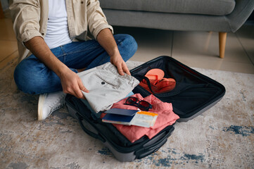 Closeup of male hands packing traveler case