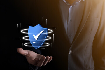 Businessman hold low poly polygon shield with a tick icon.Secure Access System Concept.Business...