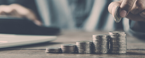 Businessman choose pile of coins stacked in a graph for money saving planning ideas.