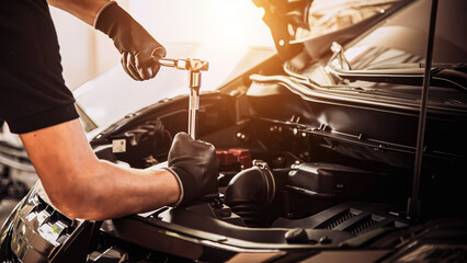 Close-up hand auto mechanic using the wrench to repairing car engine problem. Concepts of check and fix car and maintenance servicing.