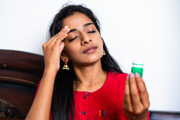 Worried teenager young girl applying balm to forehead due headache while sleeping at bedroom - concept of migraine, healthcare and treatment.