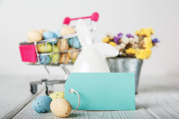 Happy Easter greeting card. Rabbits, colorful eggs, spring flowers with tag for text..