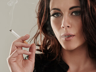 Obraz premium Shes a bad girl by nature. Portrait of an attractive young woman smoking a cigarette.