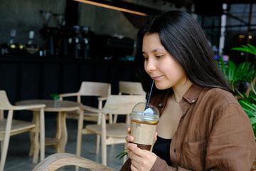The girl sits in a cafe and drinks a drink