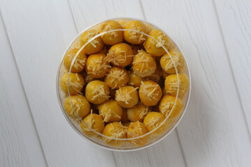 A jar of Nastar (Dutch pineapple tarts) on a white table