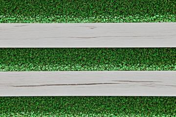 Wooden planks on synthetic green grass background. Texture with copy space.