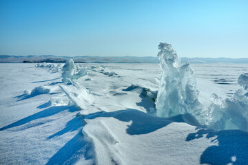 Ice hummocks on Baikal Lake in a sunny day. Winter landscape with beautiful transparent ice floes...