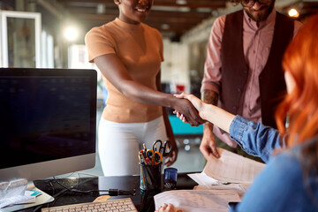 A young woman introduces herself to her new female colleague in the office