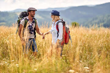  couple is hiking in mountain.Joyful couple  at meadow on sunny summer day