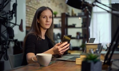 Businesswoman working with laptop computer and phone in home office. Woman using the internet, searching, browsing, Entrepreneur managing small business online.