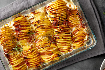 Potato gratin, backed potato slices with bacon, ham, creamy sauce. Top view.  Potato casserole