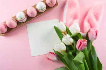 Easter flat lay composition. Easter eggs, empty card blank and spring tulips. Mockup concept.