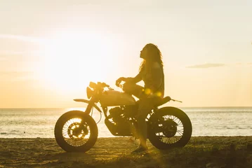 Foto op Plexiglas Vrouwelijke motorrijder die een café-racemotor bestuurt © oneinchpunch