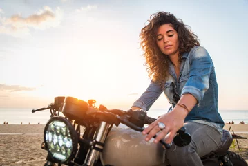 Foto op Plexiglas Vrouwelijke motorrijder die een café-racemotor bestuurt © oneinchpunch