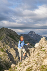 Naklejka premium Junge Frau auf dem Weg zu einem Berggipfel