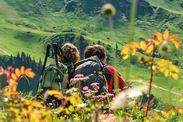 Zwei Frauen genießen den Ausblick bei einer Wandertour in den Alpen