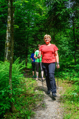 Obraz premium Drei Frauenn genißen die frische und gesunde Luft beim Nordic Walking im Wald