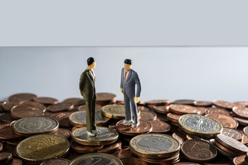 some miniature models on a surface covered with euro coins