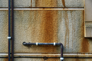 Rust and pipes on a concrete wall