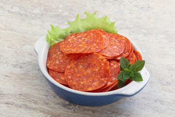 Sliced pepperoni sausage in the bowl