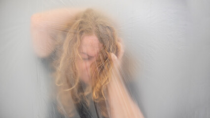 conceptual image of a mature woman grabbing her head from a headache, the position behind...