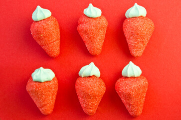 red marshmallow strawberries on a red background