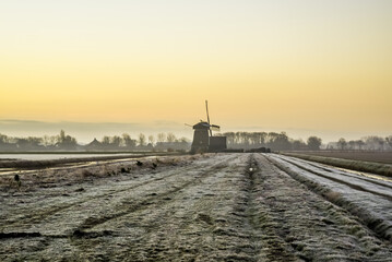 'Breezand, the Netherlands. March 2022. Sunrise in the polder with mill in background.