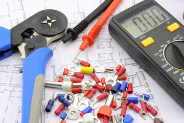 Multimeter and tools for electrical installation in a close-up schematic diagram.