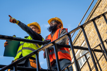 A construction supervisor inspecting the building work with a client.