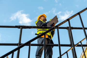 A building foreman taking notes and inspecting the construction work in site.