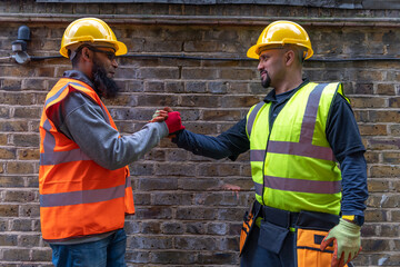 friendly, happy, smiling construction workers greeting and shaking hands.