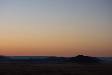 Pastel sky over Namibian landscape seen at sunrise from aerial view
