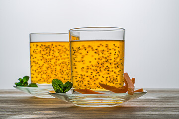 Orange drink with basil seeds. Fruit juice and seeds are healthy. On a wooden background. In glass