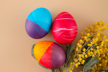 Easter eggs. Festive decoration. Easter. Celebration. Bright holiday. Eggs on a beige background. Multi-colored eggs on a beige background.