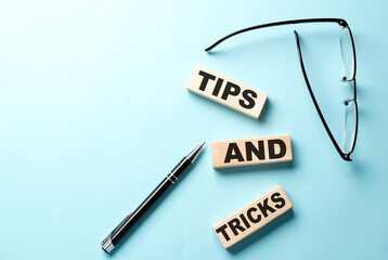 TIPS AND TRICKS text on the wooden block ,blue background