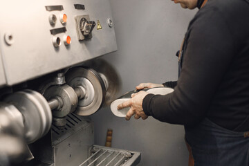 Cropped photo of a leather craftsman hands working on a shoe